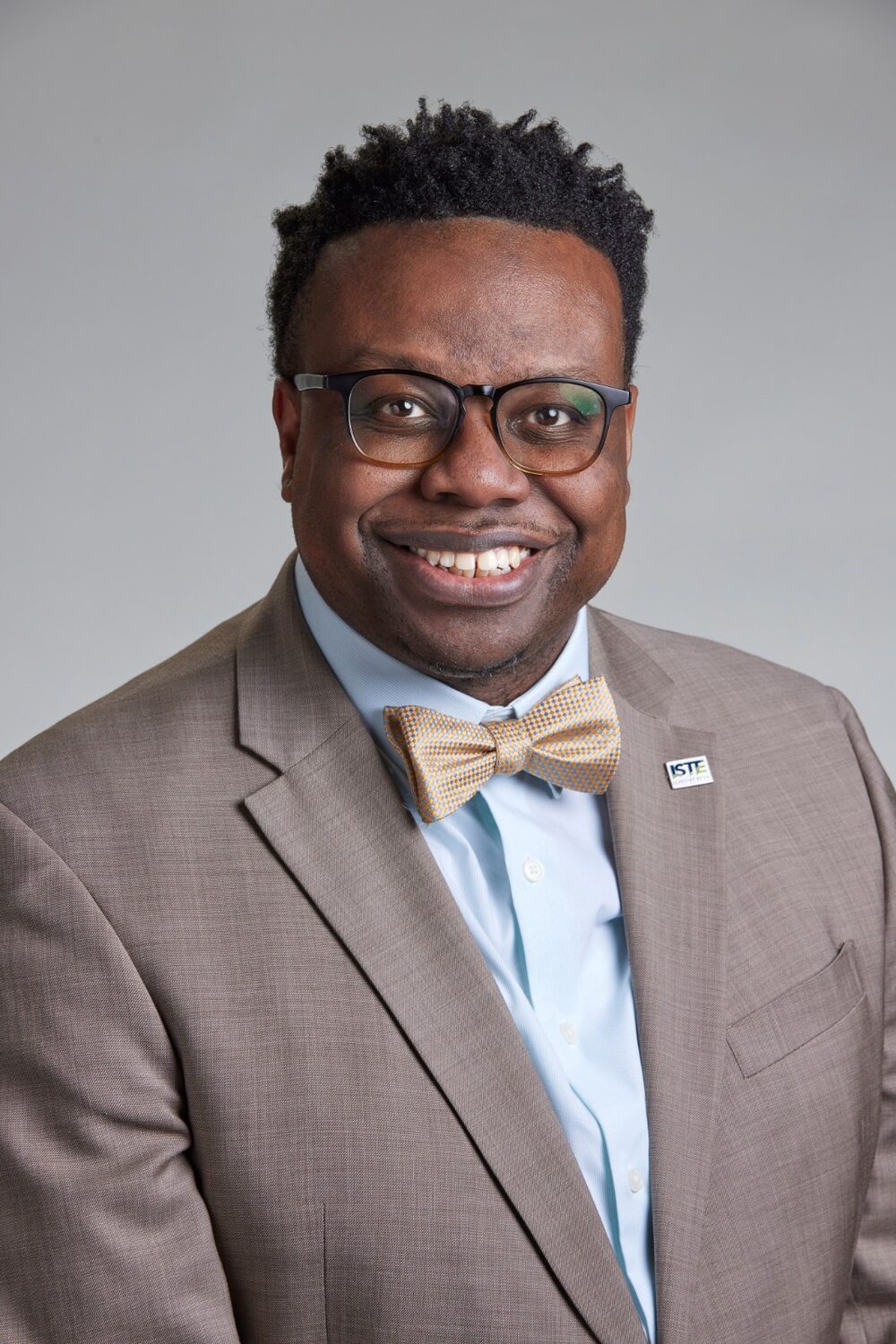 Portrait of Dr. Adam A. Phyall III in a tan suit and gold bow tie